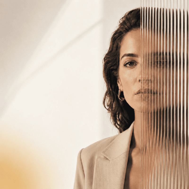 Reflexo de uma mulher através de um vidro canelado